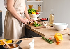 キッチンで野菜を切り料理の準備をしている様子