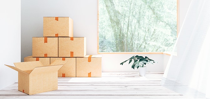 窓辺に段ボールが積まれた引っ越し準備中の室内